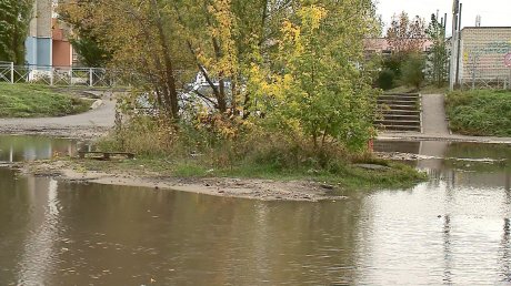 Огромная лужа на улице Антонова отрезала жильцов от дороги