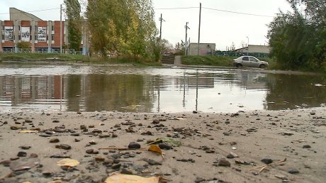 Огромная лужа на улице Антонова отрезала жильцов от дороги