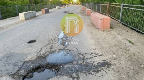 Водители петляют между ямами на мосту на Токарной
